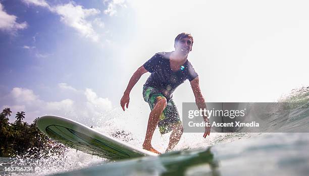 water level view of surfer riding waves - fun experience stock-fotos und bilder