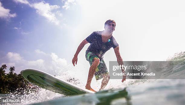 water level view of surfer riding waves - asian surfer stockfoto's en -beelden