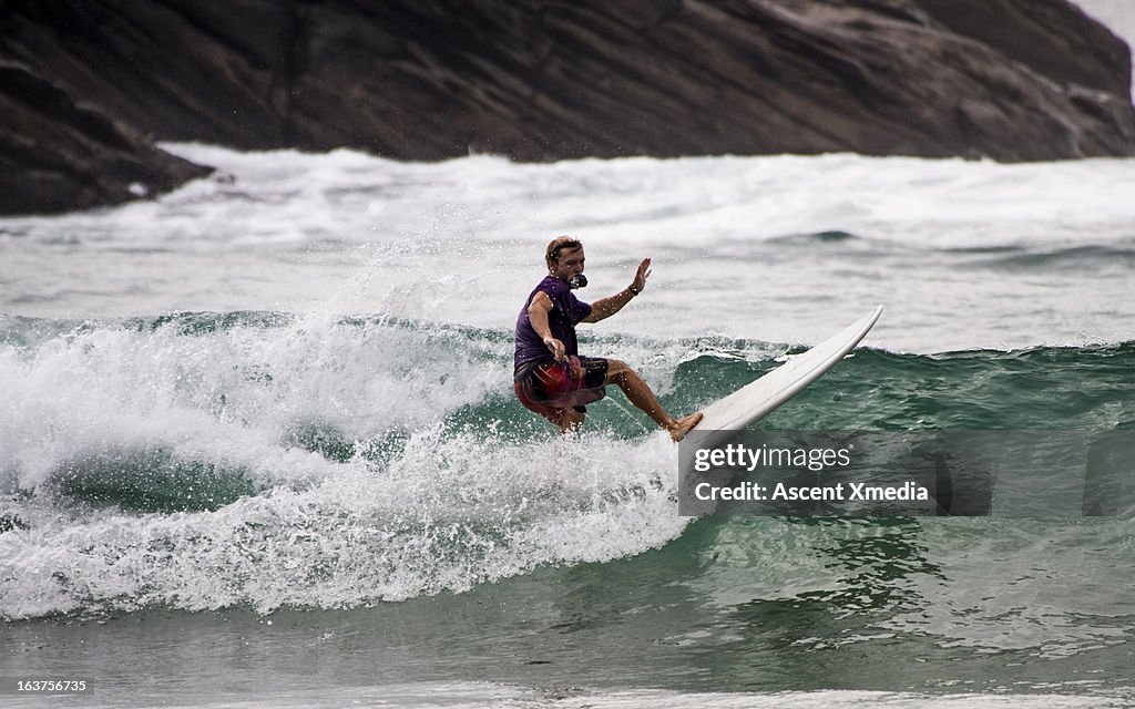 Surfer holds camera in mouth while riding waves