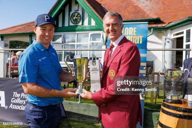 Captain Tim Rouse presents the winner Graeeme Robertson with the trophy and a bottle of Whisky following his victory on the Final Day of the Loch...