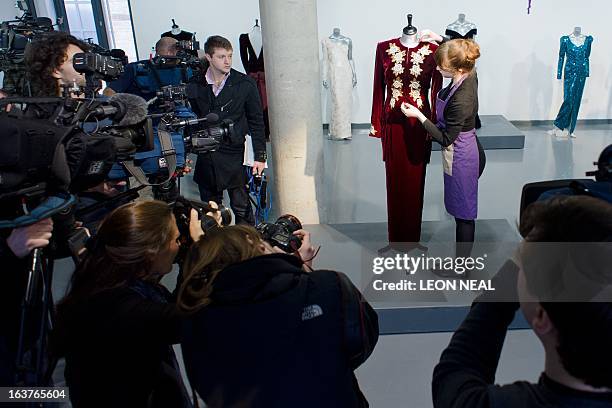 An assistant poses with a Catherine Walker tailcoat worn by Britain's Princess Diana for the State visit to Korea in 1992 at the Kerry Taylor Auction...