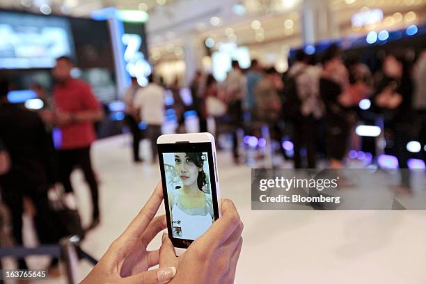 Sales assistant takes a photograph of herself with the BlackBerry Z10 smartphone during the consumer launch of the device at the Central Park Mall in...