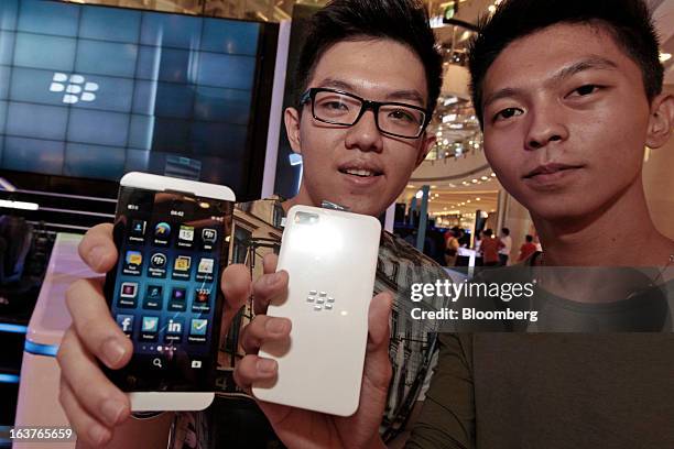 Customers hold BlackBerry Z10 smartphones for a photograph during the consumer launch of the device at the Central Park Mall in Jakarta, Indonesia,...