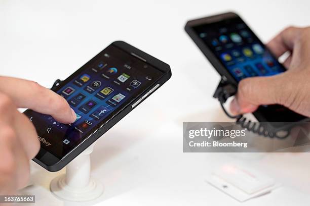 Customer tries the touchscreen of the BlackBerry Z10 smartphone during the consumer launch of the device at the Central Park Mall in Jakarta,...