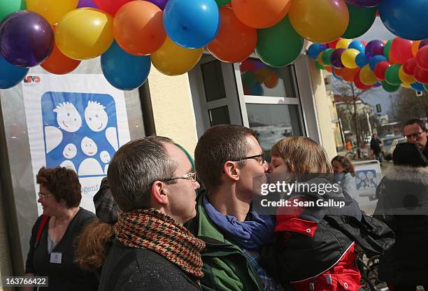 Gay couple Kai and Michael Korok nuzzle with their daughter Jana at Germany's first gay parent counseling center on its opening day on March 15, 2013...