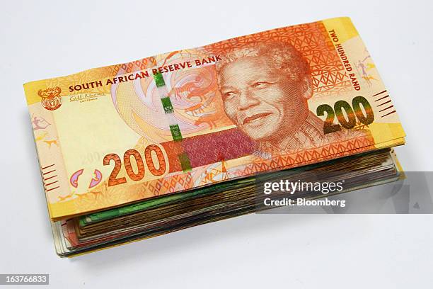 Two hundred rand currency banknote sits on top of a bundle of mixed denomination notes in this arranged photograph at a First National Bank branch in...