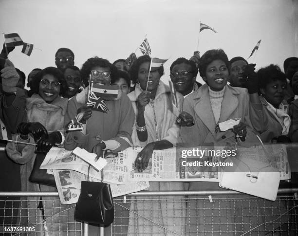 People waving small Ghanaian and British flags at London Airport from where Queen Elizabeth and the Duke of Edinburgh are leaving for their official...