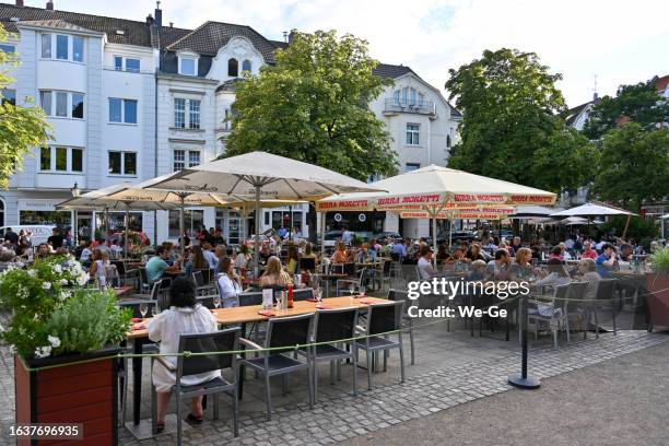 touristen und einheimische genießen den sommerabend in einem straßencafé am barbarossaplatz in düsseldorf oberkassel. - restaurant düsseldorf stock-fotos und bilder