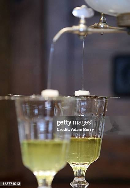 An absinthe fountain drips water through sugar cubes atop absinthe spoons sitting on glasses of absinthe on March 15, 2013 in Berlin, Germany. The...