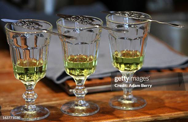 Absinthe spoons lie atop glasses of absinthe at the Absinth Depot shop on March 15, 2013 in Berlin, Germany. The highly alcoholic drink absinthe was...