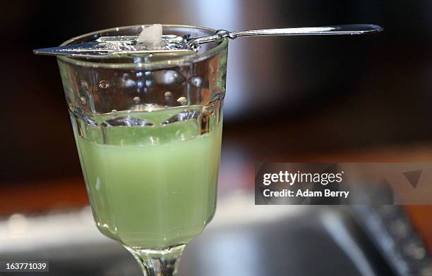 Sugar dissolves atop an absinthe spoon into a glass of absinthe at the Absinth Depot shop on March 15, 2013 in Berlin, Germany. The highly alcoholic...