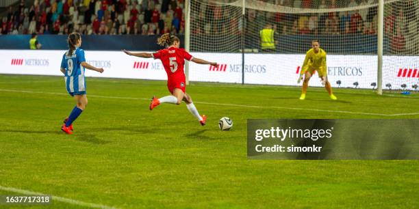 female football player kicking ball - womens soccer stock pictures, royalty-free photos & images