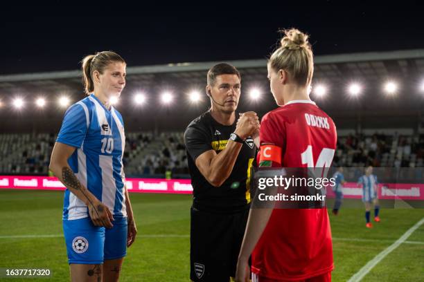 schiedsrichter mit mannschaftsbeschriftungen auf dem fußballplatz - mannschaftskapitän stock-fotos und bilder