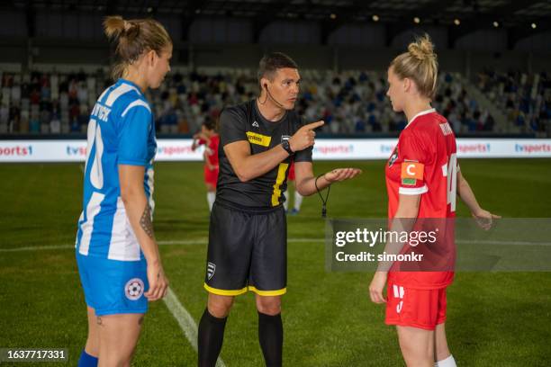 referee with team captions on football pitch - referee shirt stock pictures, royalty-free photos & images