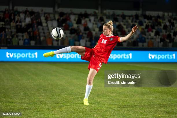 jugadora de fútbol femenino pateando pelota - dar una patada fotografías e imágenes de stock