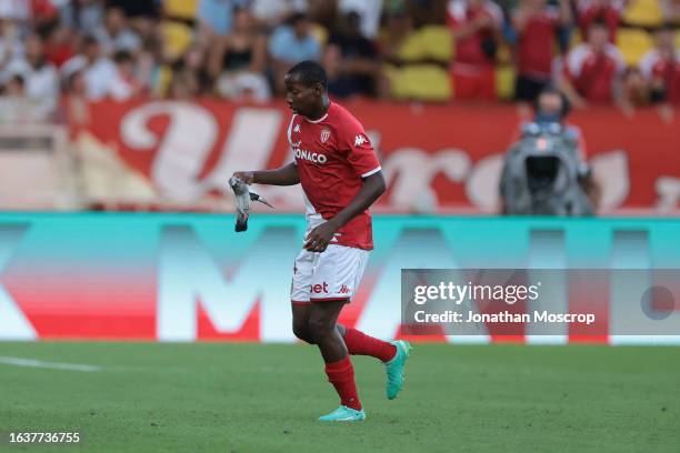 Mohamed Camara of AS Monaco recovers an injured pigeon from the field of play during the Ligue 1 Uber Eats match between AS Monaco and RC Strasbourg...