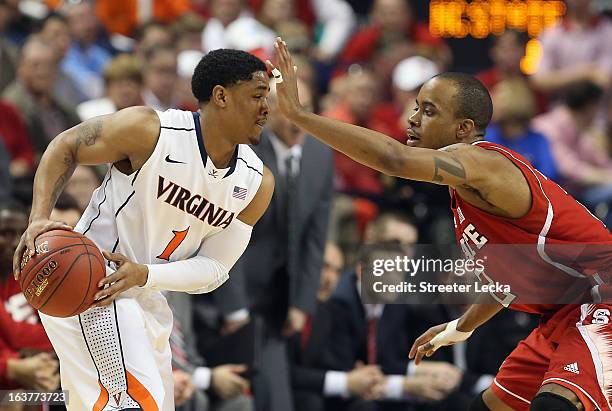 Lorenzo Brown of the North Carolina State Wolfpack guards Jontel Evans of the Virginia Cavaliers during the quarterfinals of the Men's ACC Basketball...