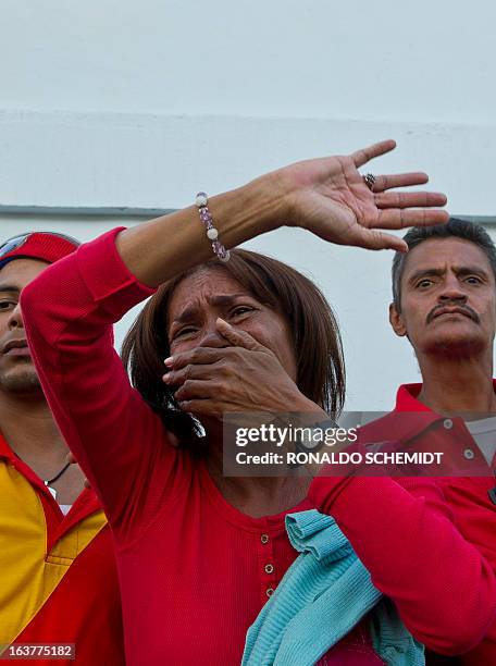 Supporters react at the passage of the coffin with the remains of late Venezuelan President Hugo Chavez being taken to former 4 de Febrero barracks...