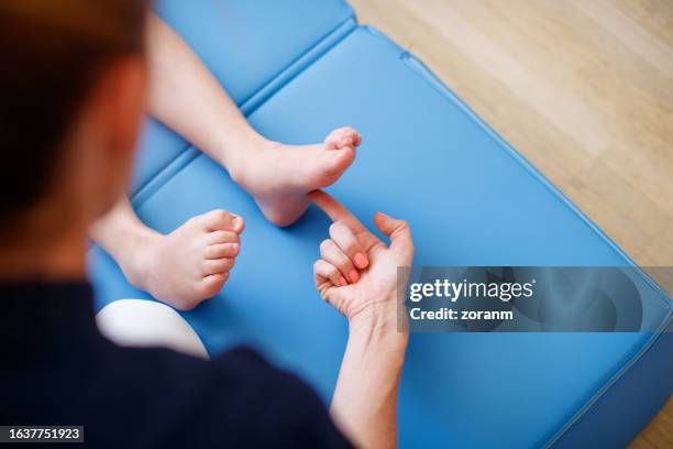 checking patient's primary reflexes on sole of his foot - tickling feet stock pictures, royalty-free photos & images