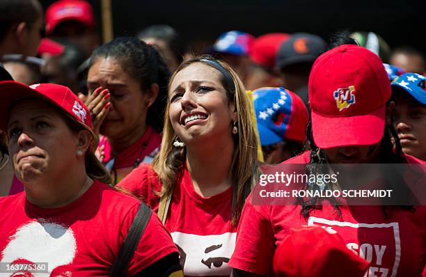 People cry as the coffin with the remains of late Venezuelan President Hugo Chavez is taken from the Military Academy to his resting place at the...