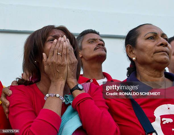 People cry as the coffin with the remains of late Venezuelan President Hugo Chavez is taken to his resting place at the former "4 de Febrero"...