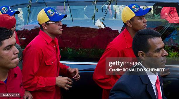 The hearse carrying the remains of late Venezuelan President Hugo Chavez heads to his temporary resting place at the former "4 de Febrero" barracks...