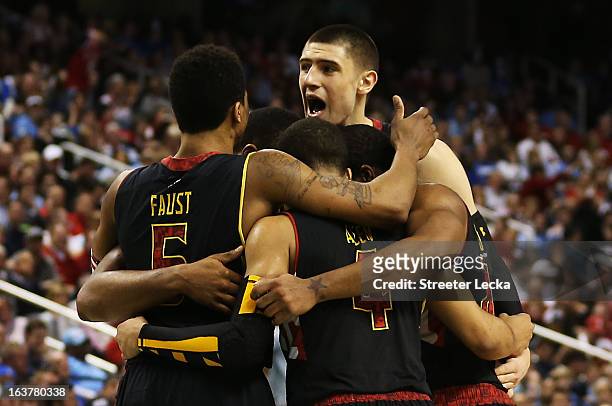 Nick Faust Seth Allen and Alex Len of the Maryland Terrapins celebrate with teammates on their way to defeating the Duke Blue Devils 83 to 74 during...