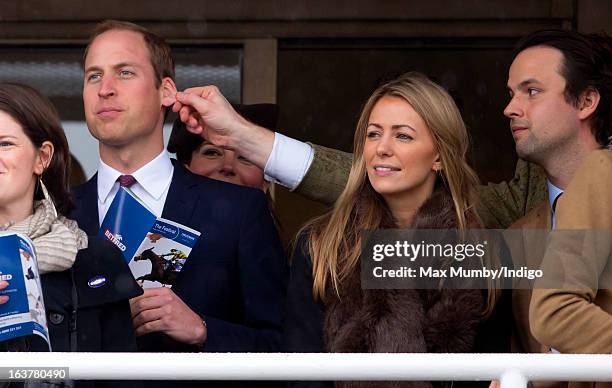 Prince William, Duke of Cambridge has his ear pulled by a friend as he watches the racing on Day 4 of The Cheltenham Festival at Cheltenham...