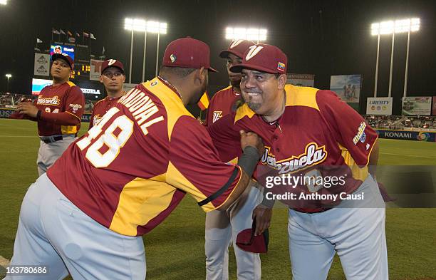 Pablo Sandoval of Team Venezuela is greeted by manager Luis Sojo of Team Venezuela during player introductions before Pool C, Game 1 between...