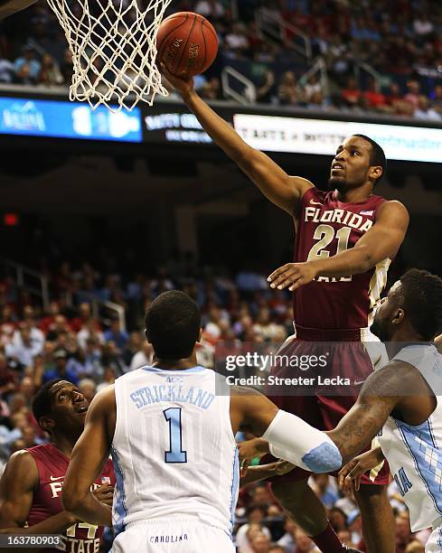 Michael Snaer of the Florida State Seminoles goes up over Dexter Strickland and Reggie Bullock of the North Carolina Tar Heels in the first half of...