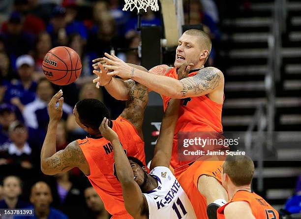 Philip Jurick of the Oklahoma State Cowboys and teammate Le'Bryan Nash rebound against Nino Williams of the Kansas State Wildcats in the first half...