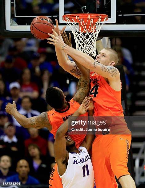 Philip Jurick of the Oklahoma State Cowboys and teammate Le'Bryan Nash rebound against Nino Williams of the Kansas State Wildcats in the first half...