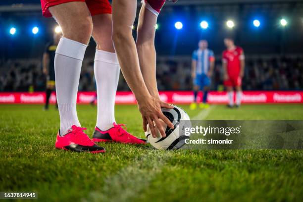giocatore di calcio che tiene il calcio a terra - inarcare la schiena foto e immagini stock