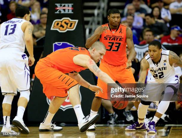 Philip Jurick of the Oklahoma State Cowboys looks to control the ball against Rodney McGruder of the Kansas State Wildcats in the first half during...