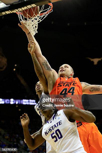 Philip Jurick of the Oklahoma State Cowboys shoots against Rodney McGruder and D.J. Johnson of the Kansas State Wildcats in the first half during the...