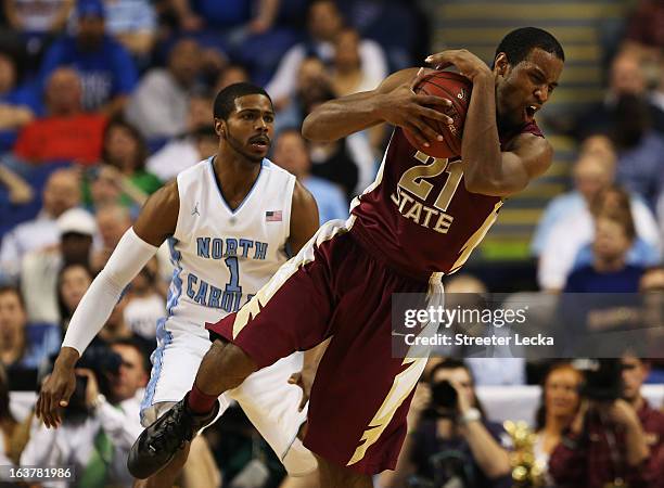 Michael Snaer of the Florida State Seminoles controls the ball against the defense of Dexter Strickland of the North Carolina Tar Heels in the second...
