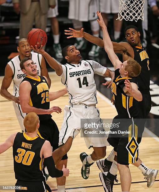 Gary Harris of the Michigan State Spartans shoots against Aaron White, Eric May, Melsahn Basabe and Mike Gesell of the Iowa Hawkeyes during a...