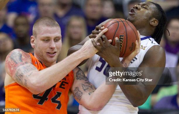 Oklahoma State's Philip Jurick battles for a rebound with Kansas State's D.J. Johnson in the first half in the Big 12 Tournament semifinals at the...