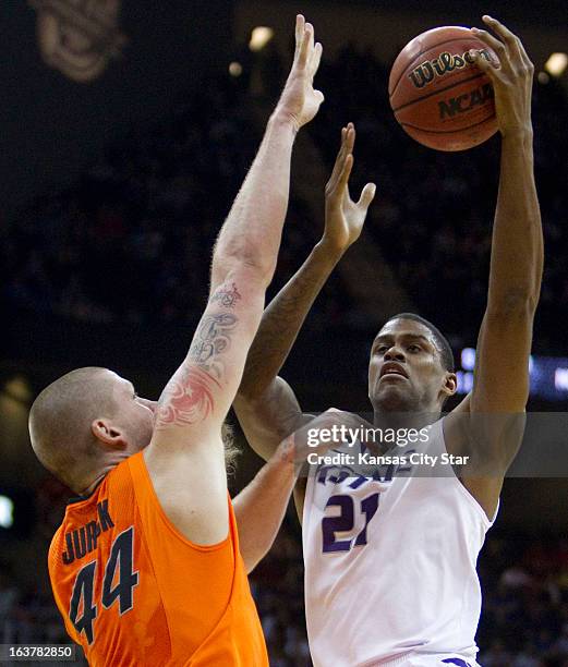 Oklahoma State's Philip Jurick defends as Kansas State's Jordan Henriquez shoots in the first half of the Big 12 Tournament semifinals at the Sprint...