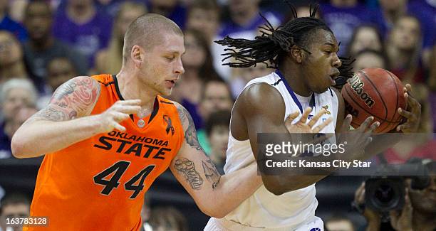 Oklahoma State's Philip Jurick has the ball ripped away by Kansas State's D.J. Johnson as they battle for a rebound in the first half in the Big 12...