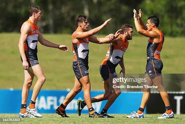 Stephen Coniglio of the Giants celebrates with team mates after kicking a goal during the AFL practice match between the Greater Western Sydney...