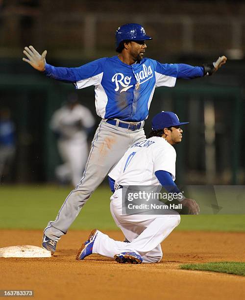 Willy Taveras of the Kansas City Royals signals safe to the umpire as Alfredo Amezaga of the Los Angeles Dodgers waits for the call on March 15, 2013...