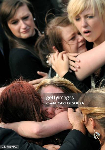 Mourners react as a procession of hearses carrying the bodies of eight British soldiers killed in Afghanistan in a 24 hour period travels through the...