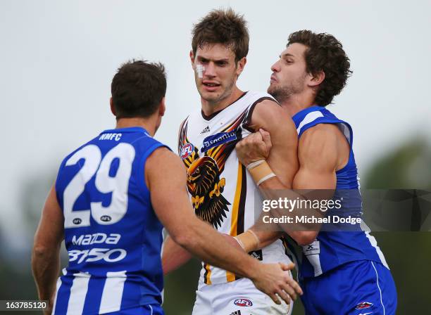 Grant Birchall of the Hawks wrestles with Brent Harvey and Aaron Black of the Kangaroos during the AFL NAB Cup match between the North Melbourne...