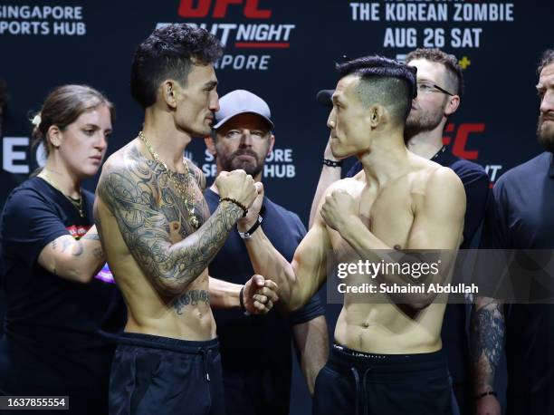 Opponents Max Holloway and Chan Sung Jung of South Korea face off during the UFC Fight Night ceremonial weigh-in at Singapore Indoor Stadium on...