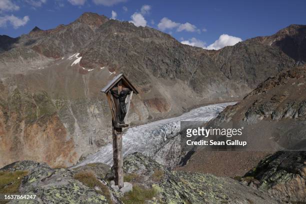 Crucifix built by alpinists stands above the tongue of the melting Gepatschferner glacier on August 22, 2023 above Kaunertal, Austria. Martin...