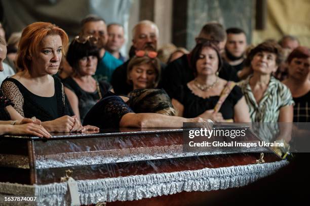 Relatives of the fallen Ukrainian soldier cry by his coffin during the farewell ceremony at the Saint Peter and Paul Garrison Church on Ukraine’s...