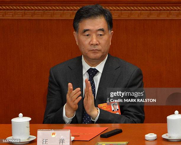 China's newly-elected Vice Premier Wang Yang applauds during the election of the new vice premiers, foreign and defence ministers of China during the...