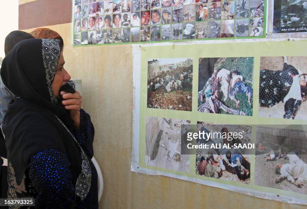 Kurdish woman cries as she looks at pictures of victims of a gas attack by former Iraqi president Saddam Hussein in 1988, at the memorial site of the...