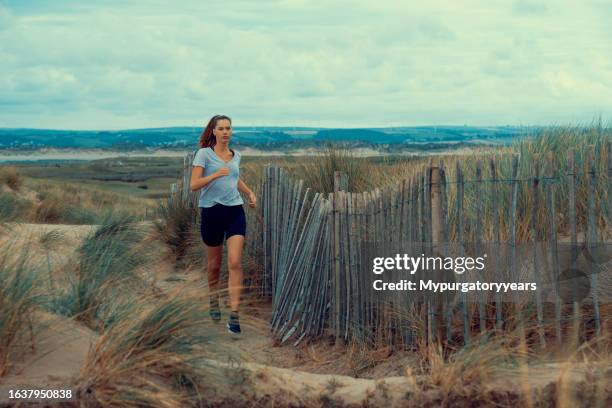 running by the beach - spandex stock pictures, royalty-free photos & images